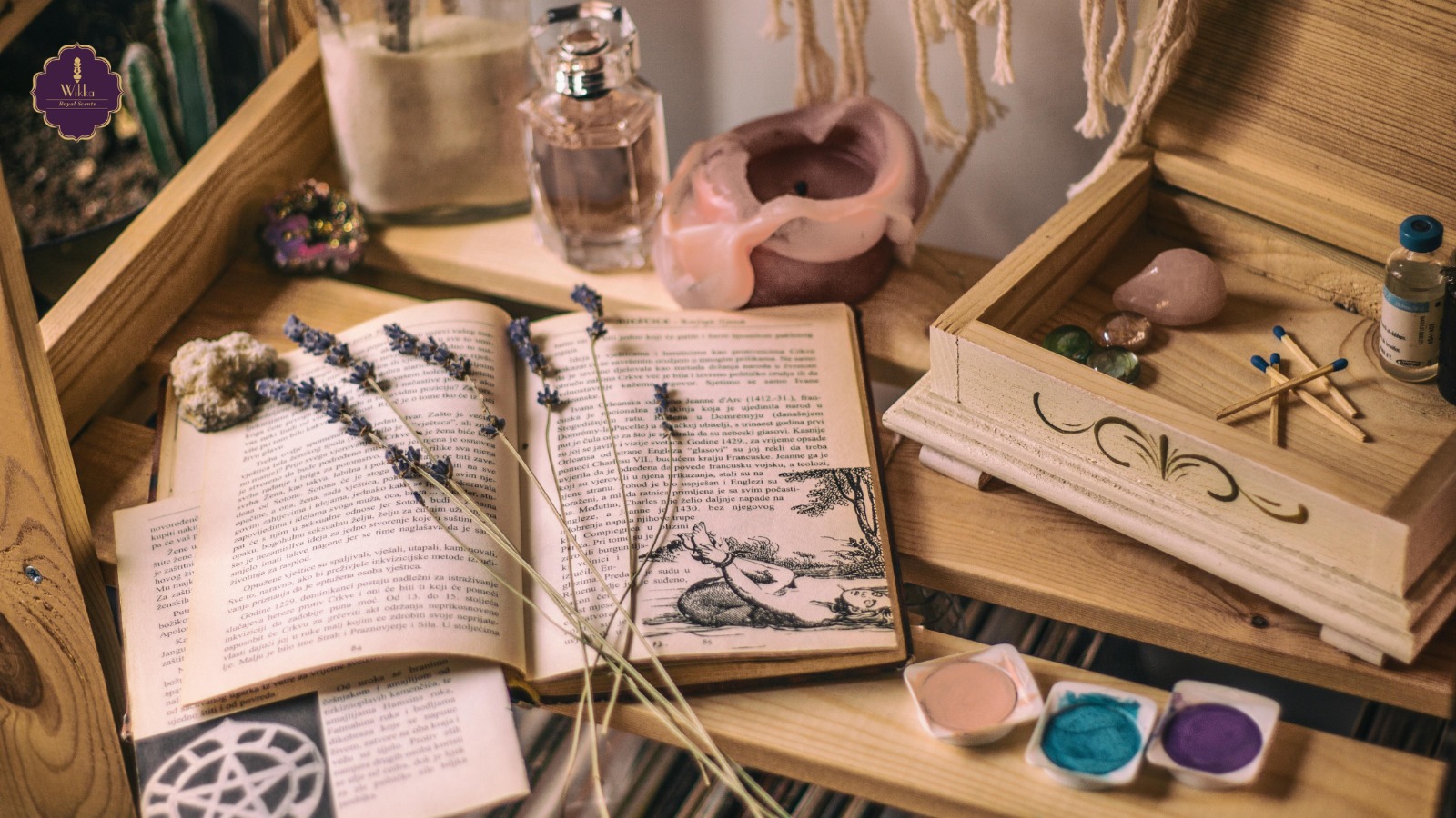 A cozy wooden setup with an open vintage book, sprigs of dried lavender, crystals, perfume bottle, candle, essential oil vial, and colorful pigments — creating a soothing, mystical ambiance. aromatherapy